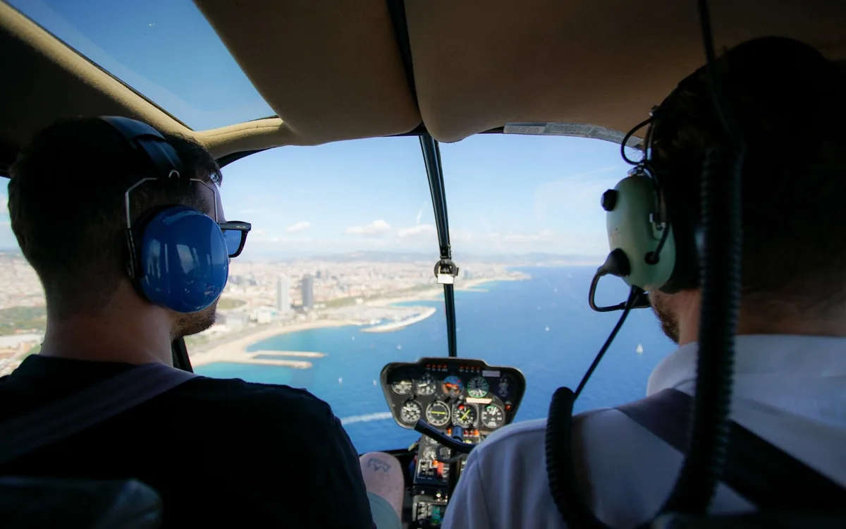 Two passengers in the cabin of a helicopter over the Barcelona coast