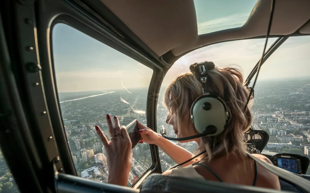 A passenger looking out over Barcelona from a helicopter cabin