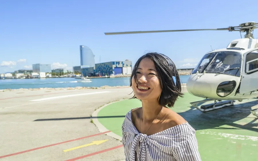 A passenger beside a helicopter at Barcelona Heliport