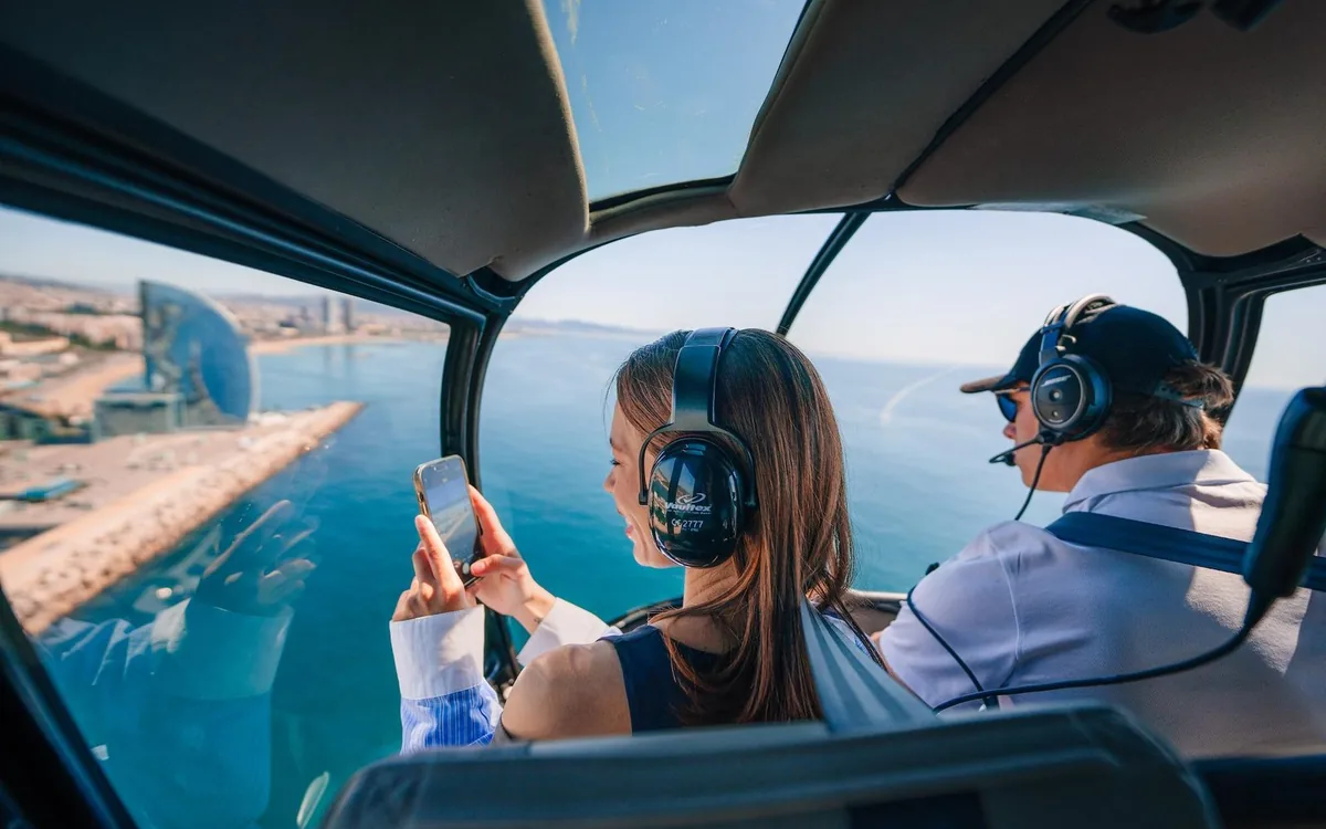 Passengers photographing the coast from a helicopter cabin over Barcelona